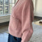 side view of model wearing pink rose cardigan with white button front and front patch pockets