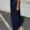 side view of model wearing navy colored cotton canvas barrel pants with side inlets