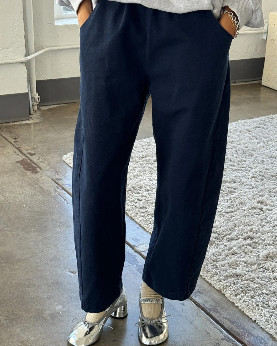 model wearing navy colored cotton canvas barrel pants with side inlets