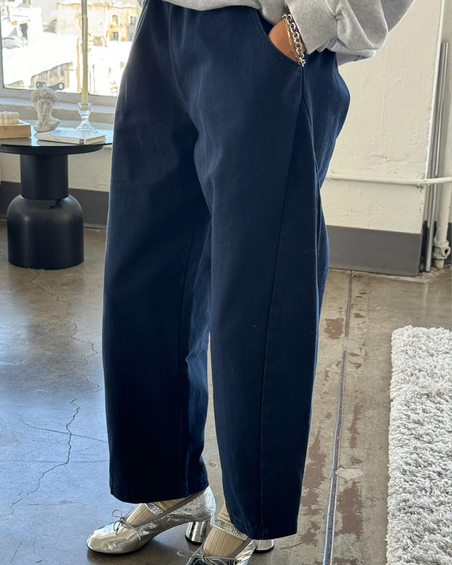 model wearing navy colored cotton canvas barrel pants with side inlets