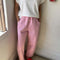 model wearing bubblegum pink cotton pants with slight balloon legs and side pockets