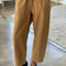 model wearing light brown cotton pants with paneling on the sides