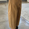 side view of model wearing light brown cotton pants with paneling on the sides