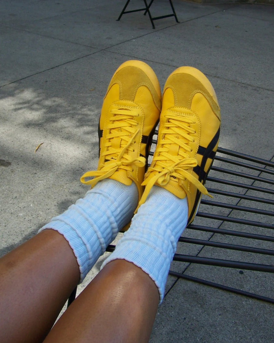 model wearing baby blue slouchy ballet socks with yellow sneakers