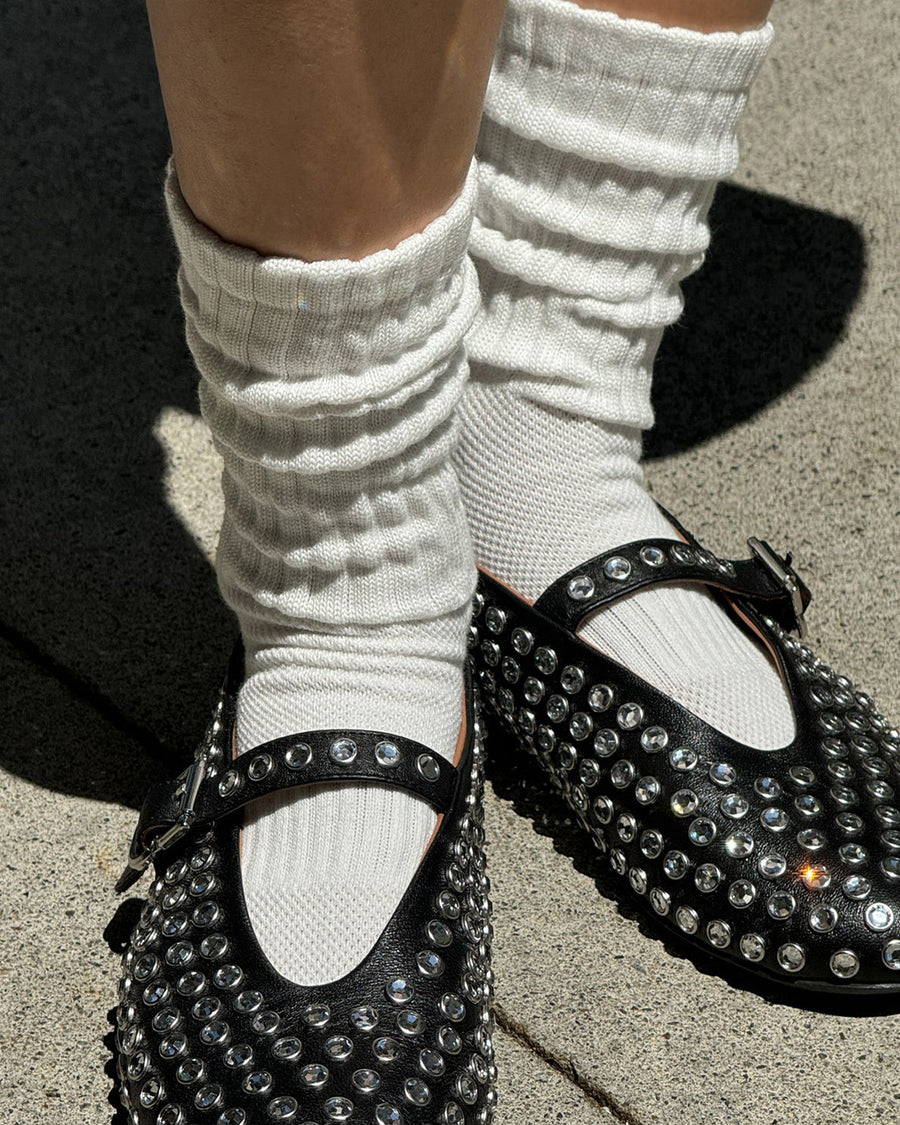 model wearing white slouchy ballet socks with pink trim with shoes on