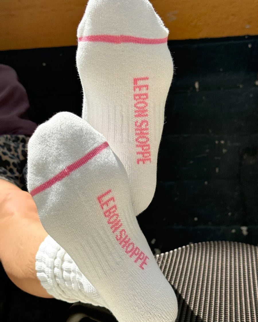 bottoms view of model wearing white slouchy ballet socks with pink trim