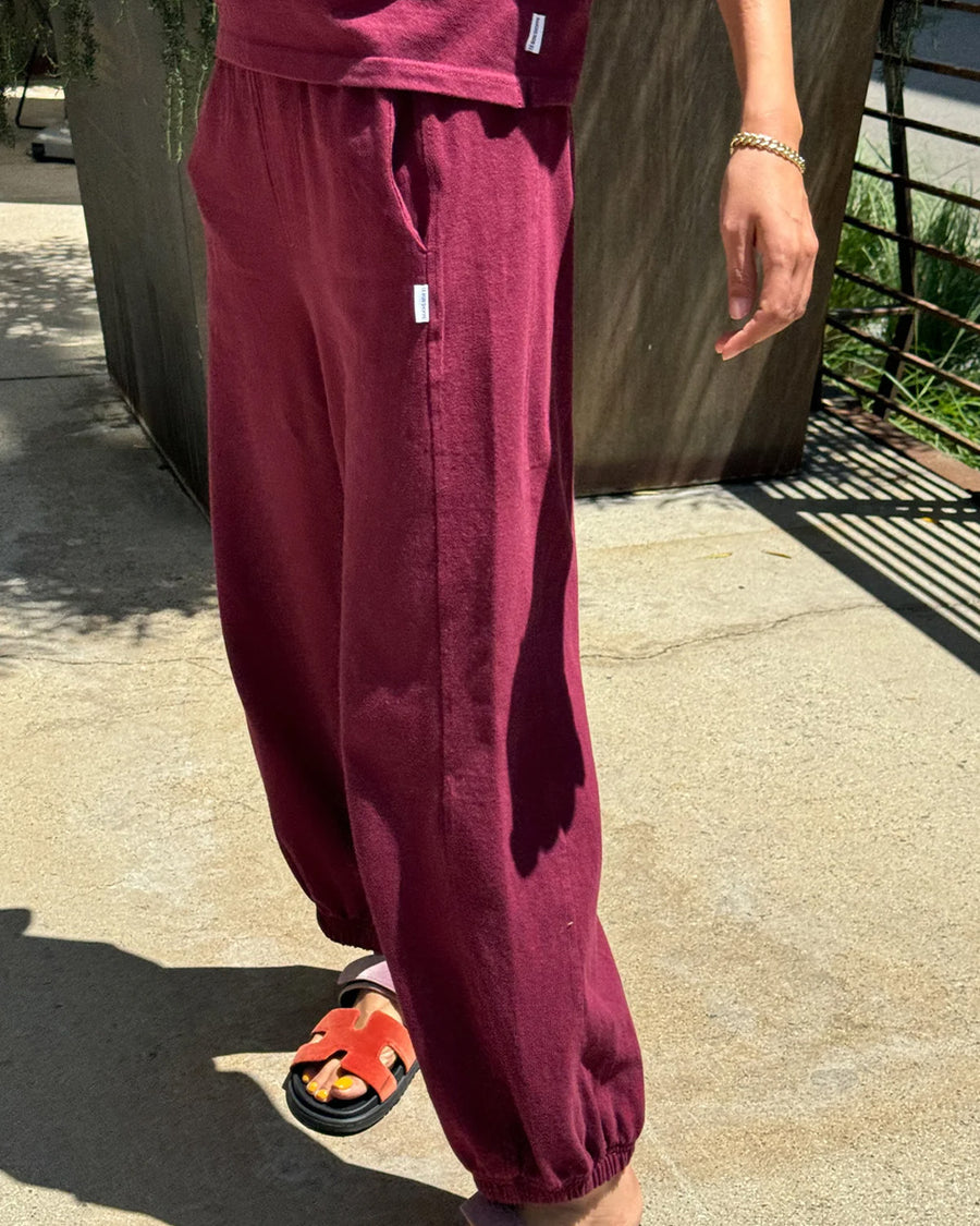 side view of model wearing cabernet colored balloon pants