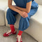 model sitting on couch wearing ocean blue cotton balloon pants with slit side pockets