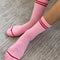 model wearing bright pink tube socks with red stripe detail