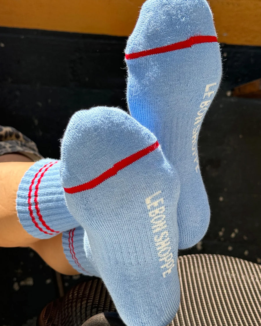 bottoms of model wearing blue socks with two red stripes on the top