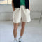 model wearing cream cotton shorts with pockets and elastic waistband