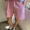 model wearing bubblegum pink cotton shorts with side pockets and elastic waistband 