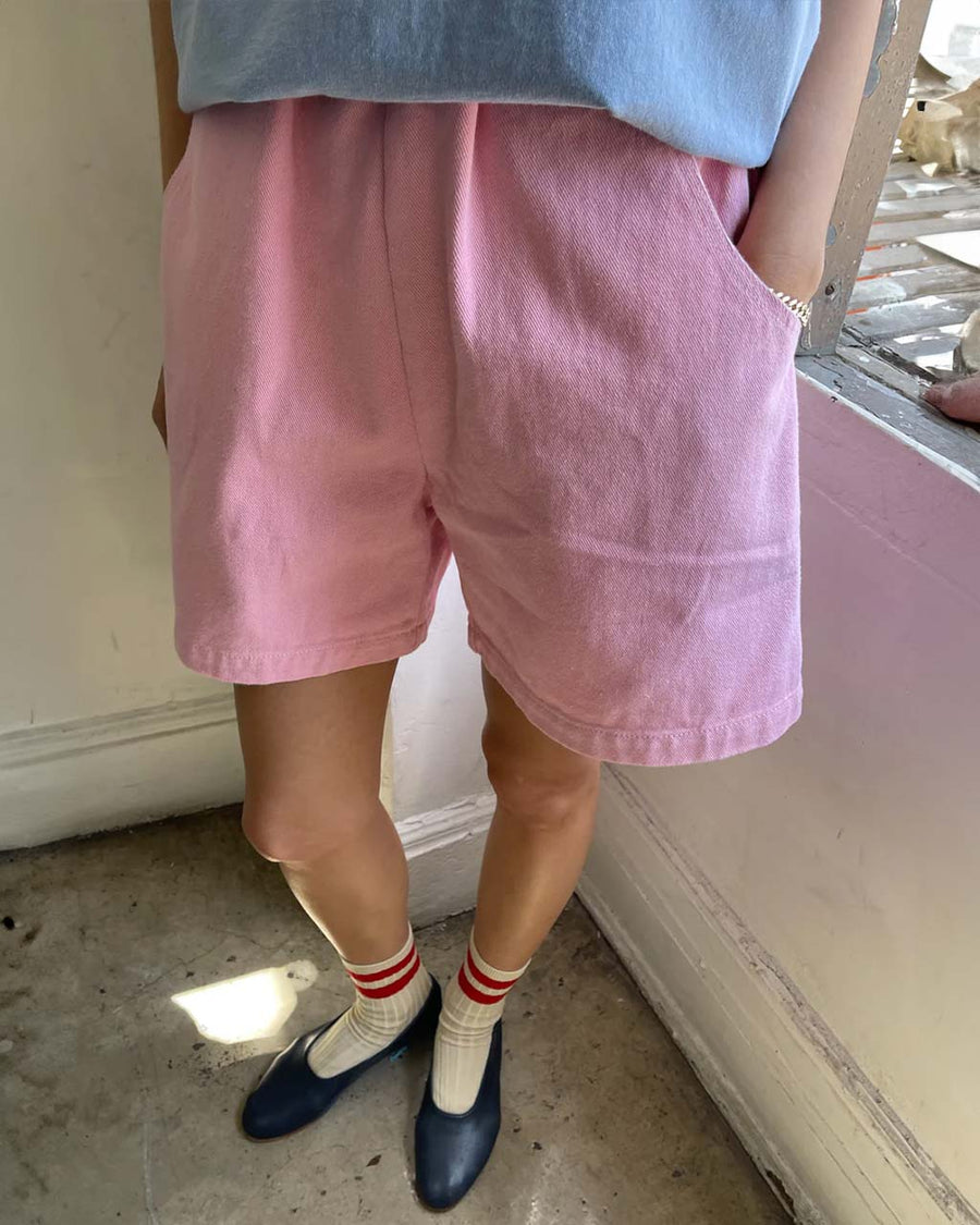 model wearing bubblegum pink cotton shorts with side pockets and elastic waistband 