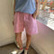 model wearing bubblegum pink cotton shorts with side pockets and elastic waistband 