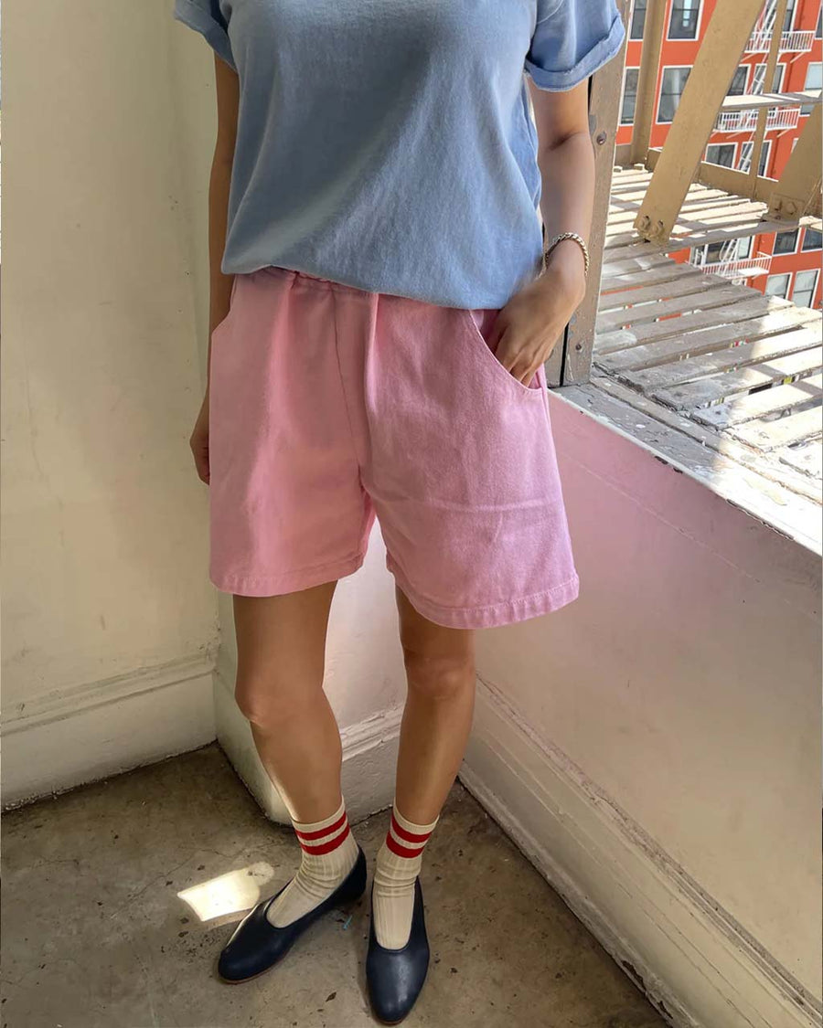 model wearing bubblegum pink cotton shorts with side pockets and elastic waistband 