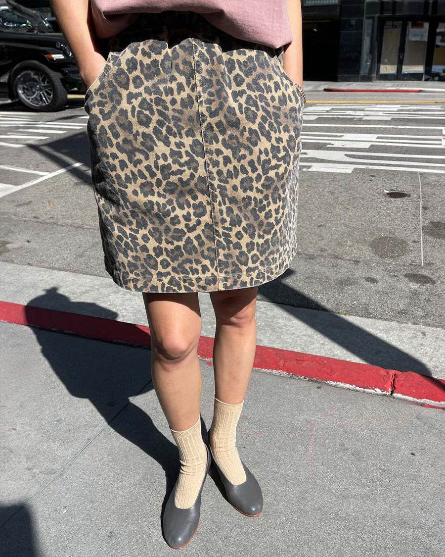 model wearing brown leopard skirt with side pockets and elastic waist in natural light