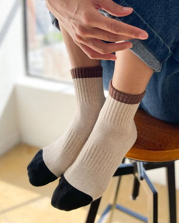 model wearing cream crew socks with brown and black trim