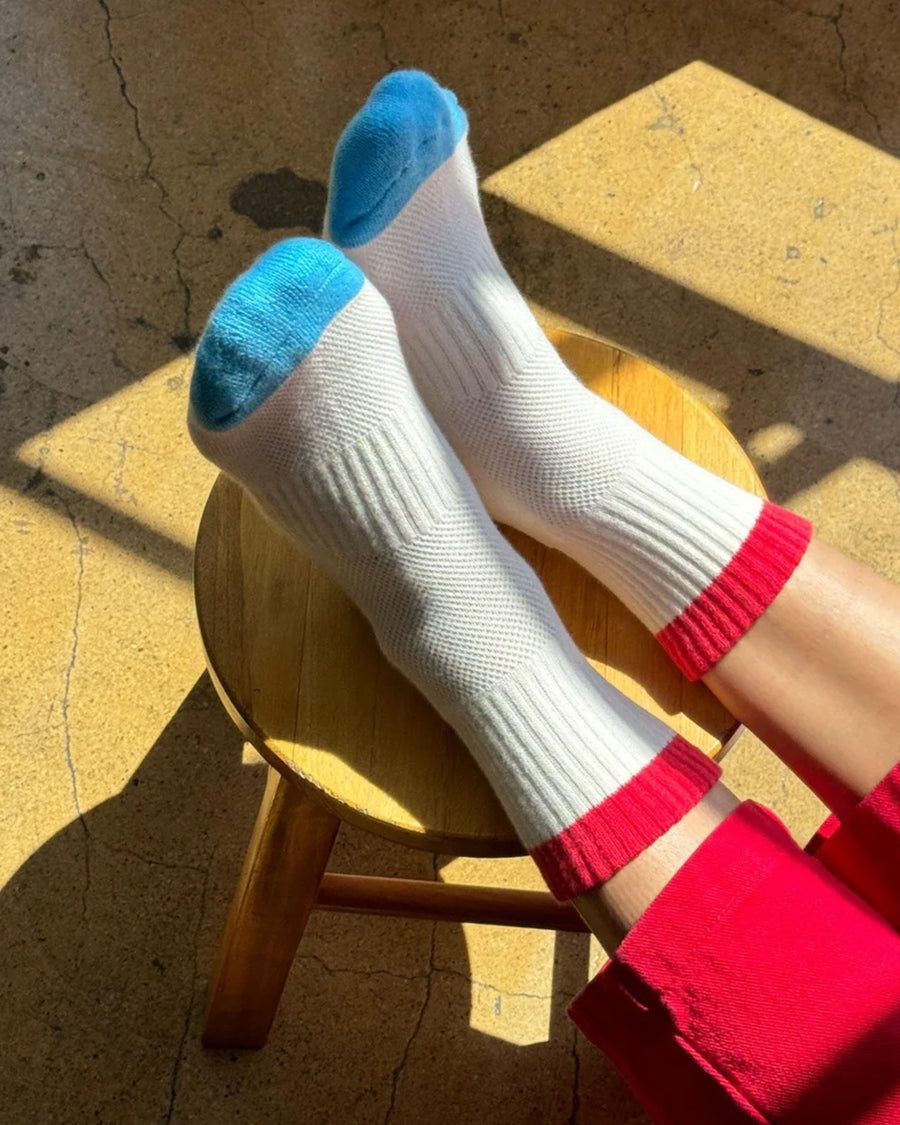 model wearing white crew socks with red and blue trim