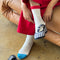 model wearing white crew socks with red and blue trim and plaid flats