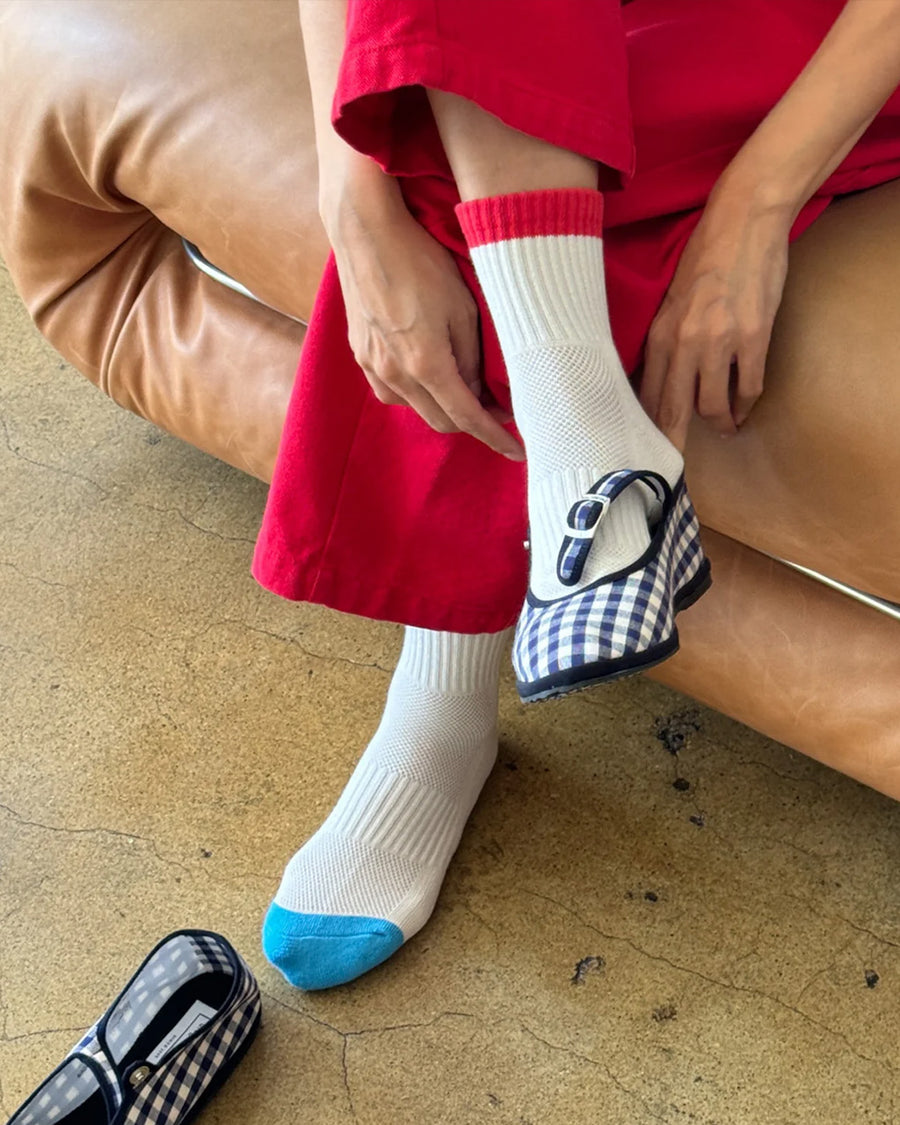 model wearing white crew socks with red and blue trim and plaid flats