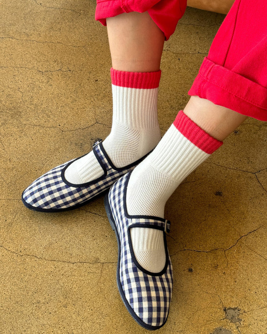 model wearing white crew socks with red and blue trim