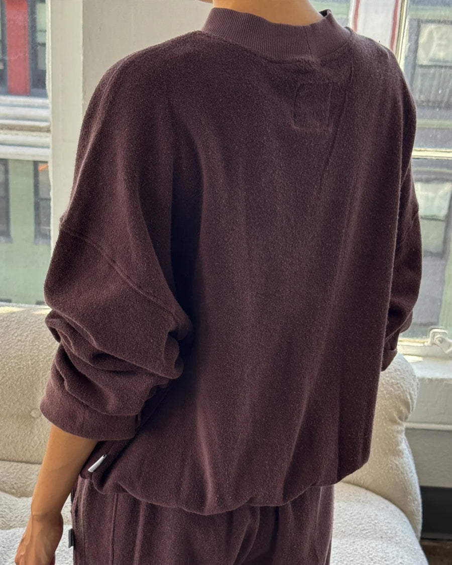 back view of model wearing brown cotton terry long sleeve top with blouson bottom