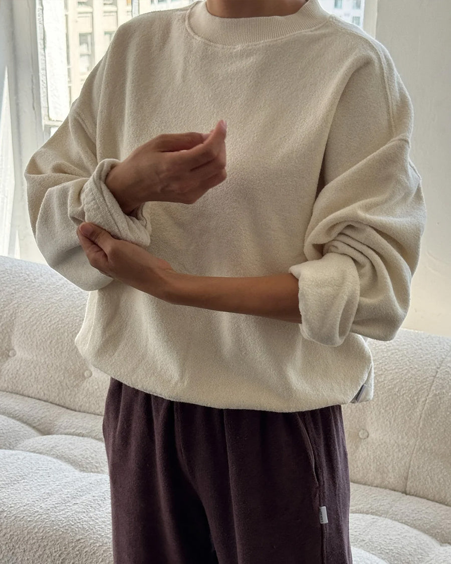 up close of model wearing brown cotton terry long sleeve top with blouson bottom