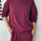 model wearing cabernet colored long sleeve mock neck top with elastic hem