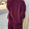 back view of model wearing cabernet colored long sleeve mock neck top with elastic hem