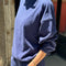 side view of model wearing midnight colored long sleeve mock neck top with elastic hem