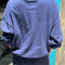 back view of model wearing midnight colored long sleeve mock neck top with elastic hem