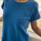 model wearing relaxed fit cobalt blue cotton tee with slight distressing on the neckline and sleeves