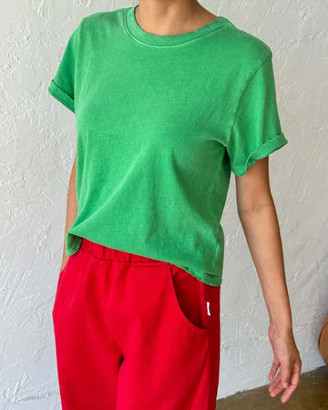 model wearing emerald green relaxed tee with slight distressing on neckline and sleeves