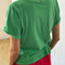 back view of model wearing emerald green relaxed tee with slight distressing on neckline and sleeves