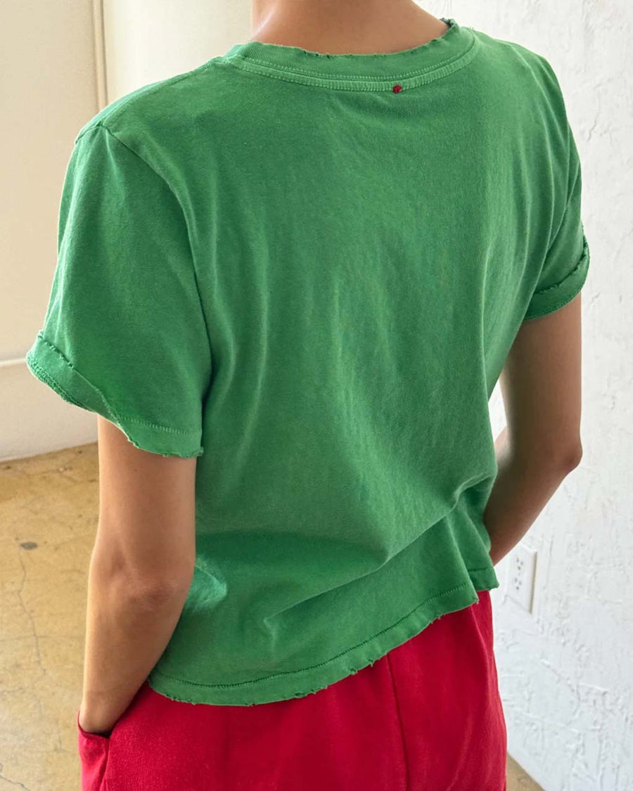 back view of model wearing emerald green relaxed tee with slight distressing on neckline and sleeves