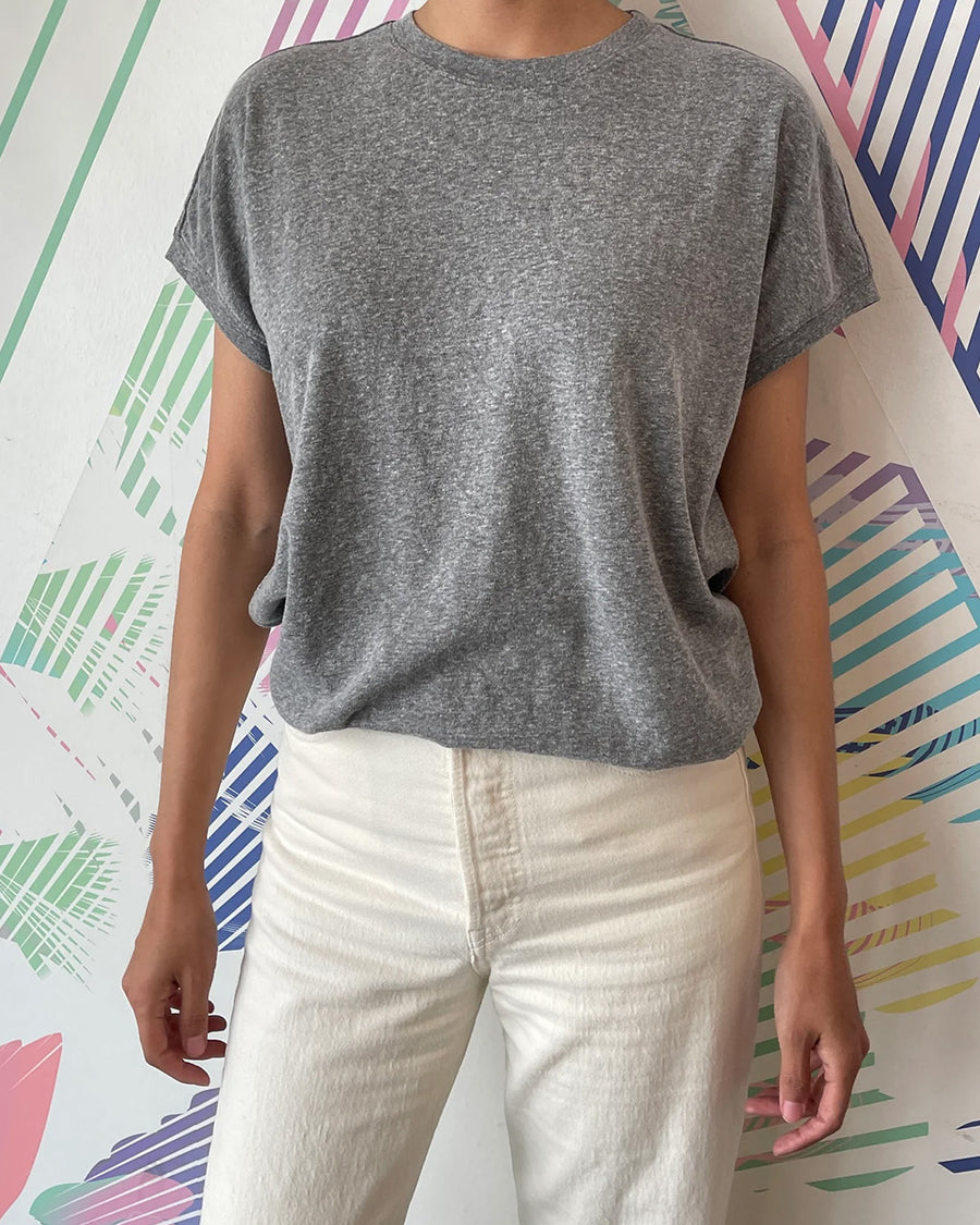 model wearing heather grey top with slight cap sleeves and relaxed fit