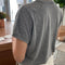 back view of model wearing heather grey top with slight cap sleeves and relaxed fit