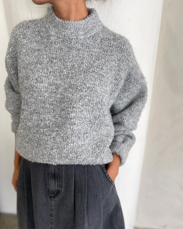 model wearing heather grey fuzzy sweater with relaxed fit and mock neck