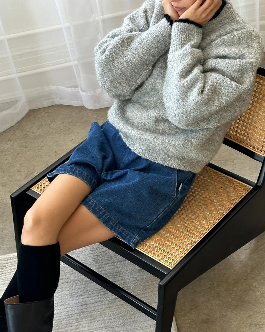 model wearing heather grey fuzzy sweater with relaxed fit and mock neck with denim shorts