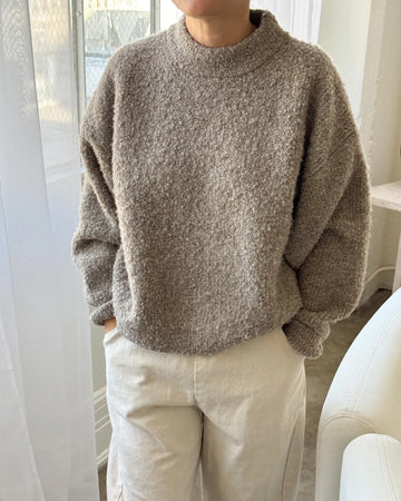 model wearing taupe fuzzy sweater with relaxed fit and mock neck