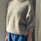 side view of model wearing taupe fuzzy sweater with relaxed fit and mock neck