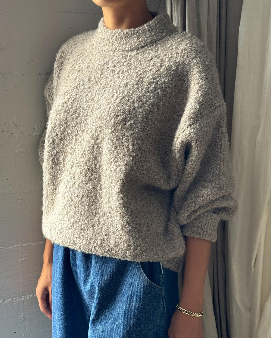 side view of model wearing taupe fuzzy sweater with relaxed fit and mock neck