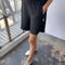 model wearing black cotton flared basketball shorts with side pockets and side slits