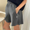 side view of model wearing coal flared cotton basketball shorts with pockets