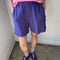 model wearing eggplant purple cotton shorts with elastic waist and side pockets