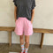 model wearing bubblegum pink flared cotton basketball shorts