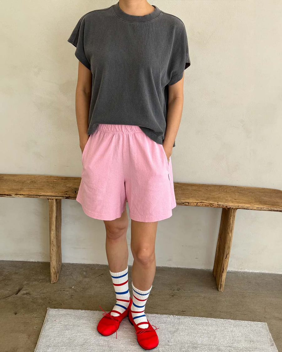 model wearing bubblegum pink flared cotton basketball shorts