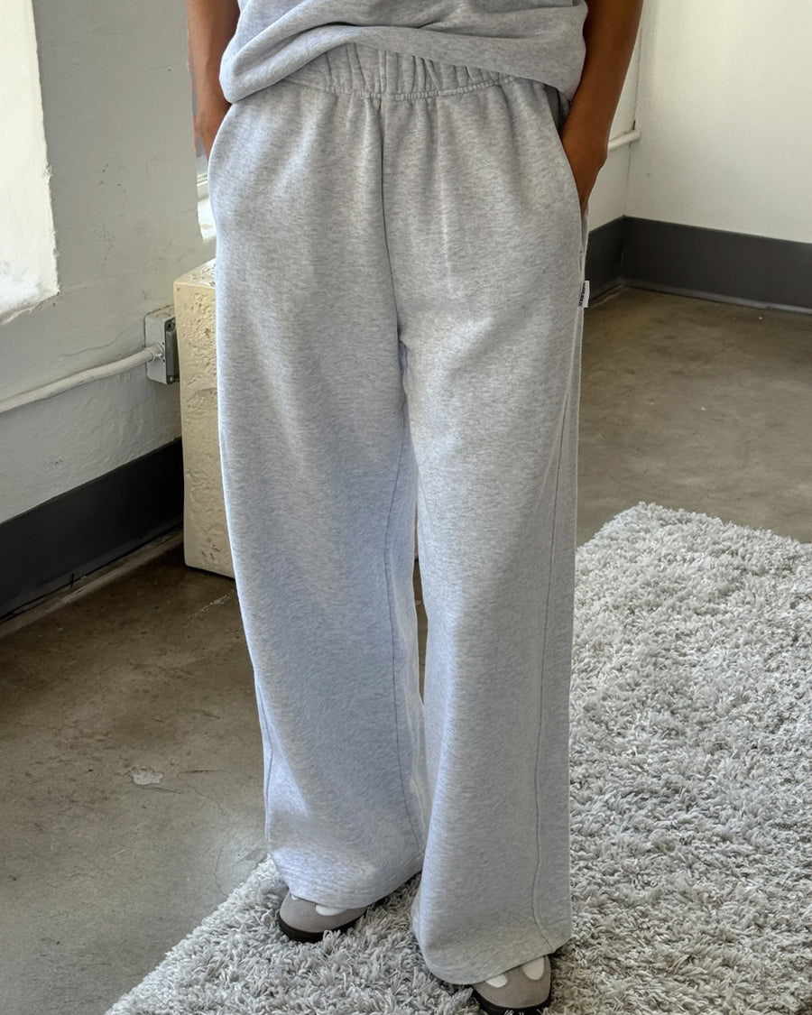 model wearing relaxed heather grey sweatpants with side pockets