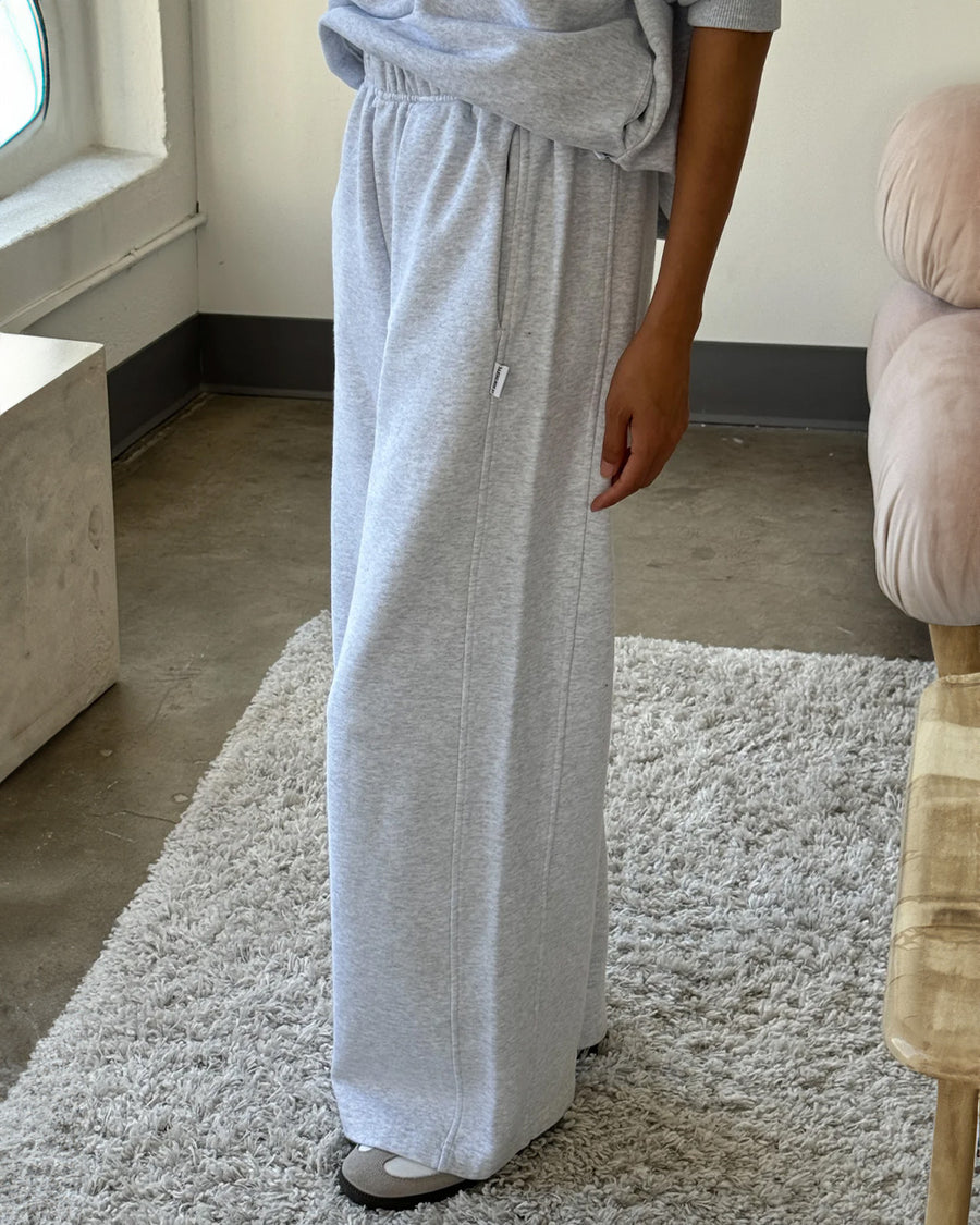 model wearing relaxed heather grey sweatpants with side pockets