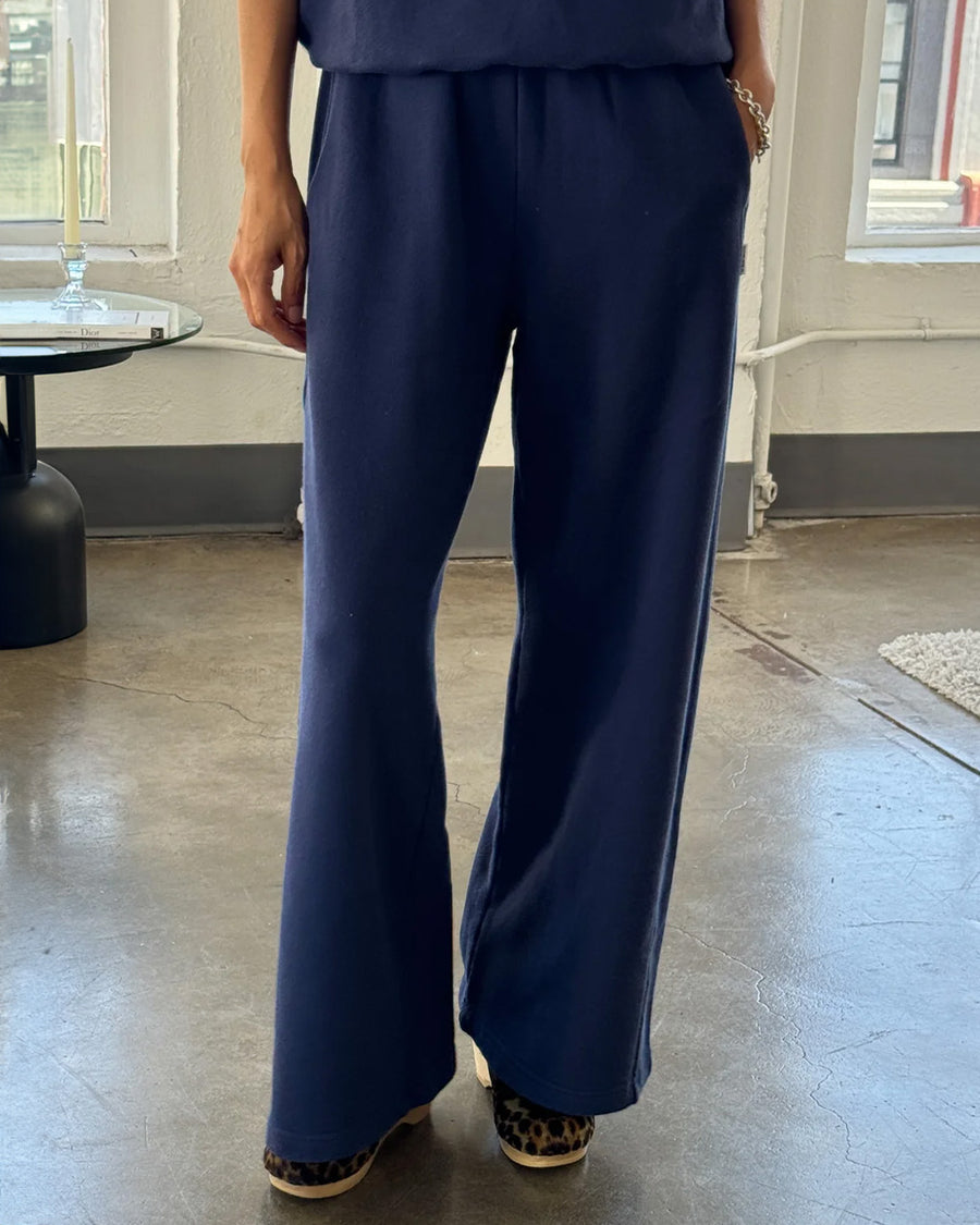 model wearing relaxed navy sweatpants with side pockets